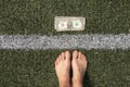 dollar lies near the strip on the grass and near the bare feet of a woman, financial theme, dollar