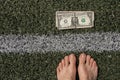 dollar lies near the strip on the grass and near the bare feet of a woman, financial theme, dollar