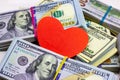 Dollar packs and big red paper heart on money background