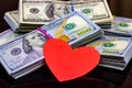 Dollar packs and big red paper heart on money background. Sex, love and prostitution concept.