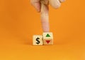 Dollar rates symbol. Businessman turns a cube, changes the direction of an arrow symbolizing that dollar rates are going down or Royalty Free Stock Photo