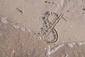 Dollar sign painted on the sand of beach is washed off by a sea Royalty Free Stock Photo