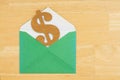 Dollar sign symbol with green envelope on textured wood background Royalty Free Stock Photo