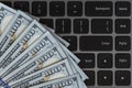 Dollars banknotes and black laptop keyboard