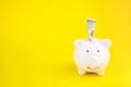 Dollars banknotes money into piggy bank on yellow background. Saving money and financial concept. Royalty Free Stock Photo