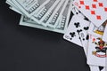 Dollars and cards on a black table.