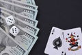 Dollars, dice and cards on a black table. Royalty Free Stock Photo