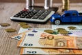 Dollars, euros, coins, a calculator and a toy blue car on a wooden background Royalty Free Stock Photo