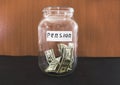 Dollars in a glass jar on black. Saving money. Pension concept.