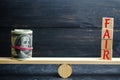 Dollars and the inscription `Fair` on wooden blocks. Balance. Fair value pricing, money debt. Fair deal. Reasonable price. Justifi