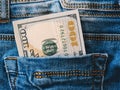 Dollars in a jeans pocket, closeup.A few bills of one hundred dollars stick out of the back pocket of jeans.finance Royalty Free Stock Photo