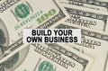 On the dollars lies a paper plate with the inscription - Build Your Own Business