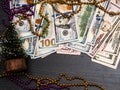 Dollars money laying in Christmas fir tree branches on burnt wooden board surface background. Christmas decorations. Royalty Free Stock Photo