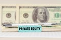 On the dollars are a pen and a sign with the inscription - Private equity Royalty Free Stock Photo