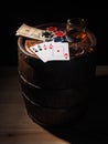 Dollars and playing cards on a wooden barrel