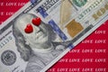 100 dollars on a red background with inscriptions love. red hearts close their eyes. love of money and greed concept Royalty Free Stock Photo