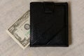 20 dollars sticking out of a wallet of dark leather on a gray background Royalty Free Stock Photo