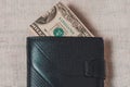 20 dollars sticking out of a wallet of dark leather on a gray background Royalty Free Stock Photo