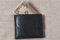 20 dollars sticking out of a wallet of dark leather on a gray background Royalty Free Stock Photo
