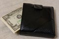 20 dollars sticking out of a wallet of dark leather on a gray background Royalty Free Stock Photo