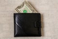 20 dollars sticking out of a wallet of dark leather on a gray background Royalty Free Stock Photo