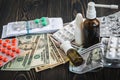 Of dollars on the table on the background of medical AIDS, expensive drugs