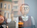 Dolls depicting a student and strict teacher with glasses and with a book in hand in a window of a Moscow Puppet Theater. Building