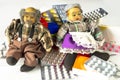 Dolls of elderly couple sit on heap of assorted medicine tablets and pills. Expensive medicines, medical care and treatment for