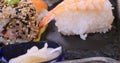 Dolly close up push in view of an assortment of Japanese food: sushi, nigiri, sashimi