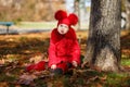 Dolly pin-up toothsome young girl wearing red blushful winter jacket and warm hat with boots fashion stylish clothes posing in aut