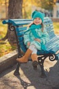 Dolly pin-up toothsome young girl wearing turquoise light blue jacket and warm hat fashion stylish clothes posing in autumn spring