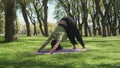Dolly right shot of a woman doing a yoga excersise on a beautiful park