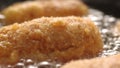 Dolly shot of Breaded Cutlets Sizzle in Frying Pan.