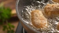 Dolly shot of Breaded Cutlets Sizzle in Frying Pan.