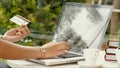 Asian woman typing and transaction credit card on laptop