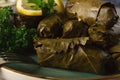Dolma, cabbage rolls, grape leaves with filling, white sauce, lemon and herbs, rustic, selective focus, no people, Royalty Free Stock Photo