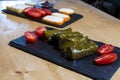 Dolma, delicious Casucasian and Turkish cuisine, vine leaves stuffed with minced meat and rice. traditional hummus cream and Royalty Free Stock Photo