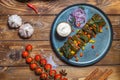 Dolma in grape leaves on a platter on a brown wooden background, decorated with spices, chili peppers, cherry tomatoes Royalty Free Stock Photo