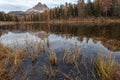 Dolomite lake shore with reflections of mountains and trees with autumn colors