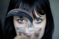 Dolphin jumps out from the glass of water in front of young woman