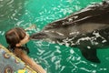 Dolphin kisses a girl, swimming with a dolphin, communication with animals. Bright emotion