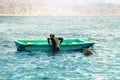 The dolphin plays with a diver near a boat in the Red Sea