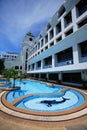 Dolphin swimming pool, sun loungers next to the garden and buildings Royalty Free Stock Photo