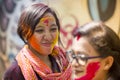 A woman smeared with colored powder, takes part in celebrations of the Dol Utsav Festival.