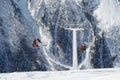 Double-chair ski lift with people on the background of the Caucasus Mountains ridge on a sunny winter day Royalty Free Stock Photo