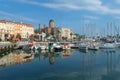 Saint Raphael, France - June 18th 2018: A waterfront scene showing the basilica overlooking shops, restaurants and the marina.