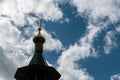 The dome of the Church with a cross on the sky background with white clouds. Royalty Free Stock Photo