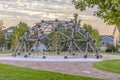 Dome climbing frame and homes under a cloudy sky