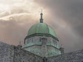 Dome of Galway Cathedral with cross on a bright cloudy sky and ray of light going, Concept religion, hope