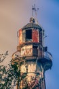 Dome of an old rusty metal lighthouse in the sun rays. Toned image